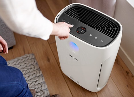 Person changing the mode on small room air purifier
