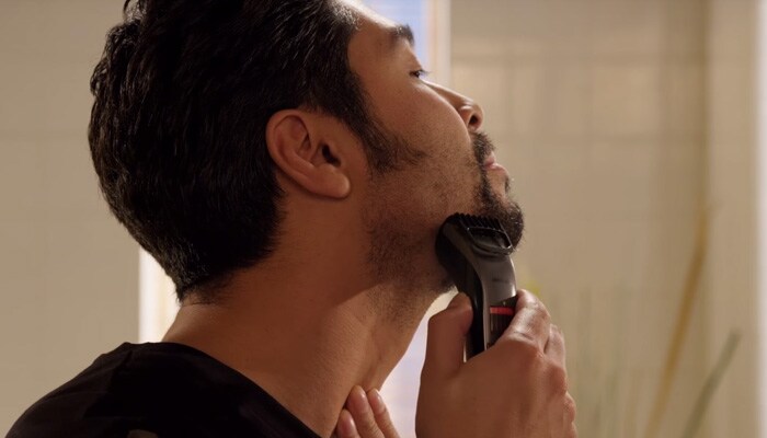 Man trimming his stubble beard with a beard trimmer