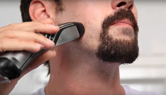 Man trimming around his goatee beard