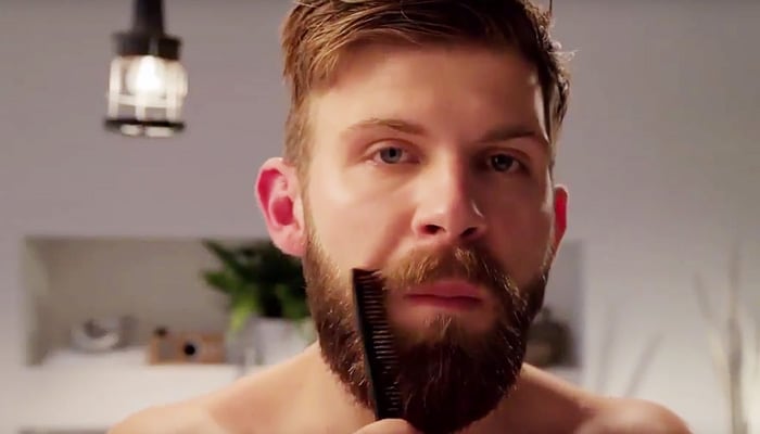 Man combing through healthy looking beard
