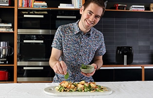 Male cooking coconut prawns  mango, cucumber and mint salad with callum hann