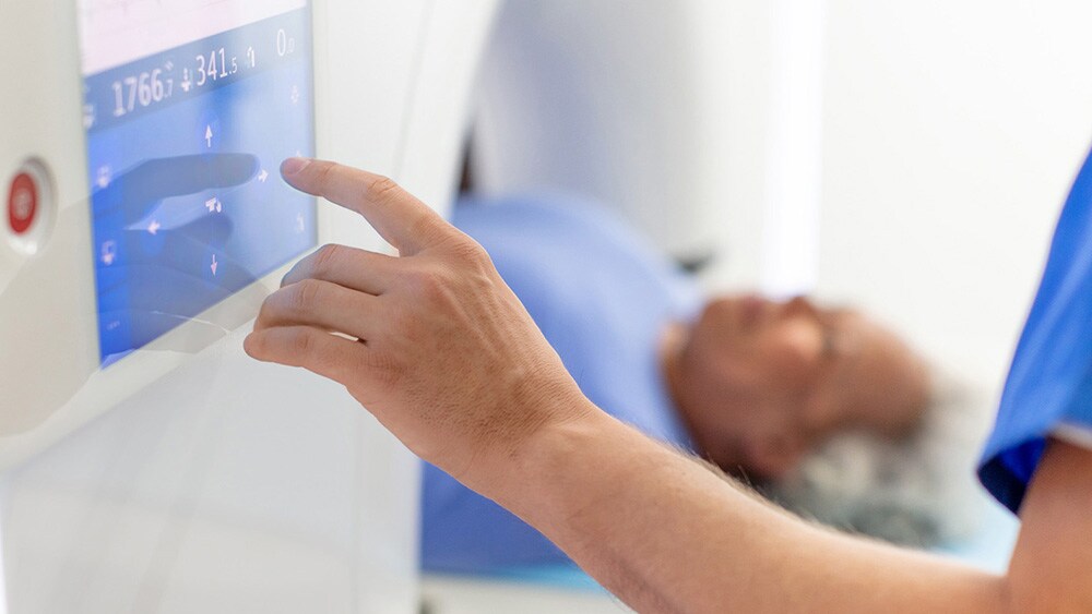 A radiology technologist operating a CT machine